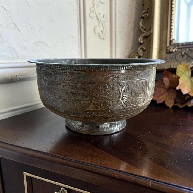 An engraved copper bowl with calligraphic cartouches and geometric floral engraving brings detailed Old World character to...