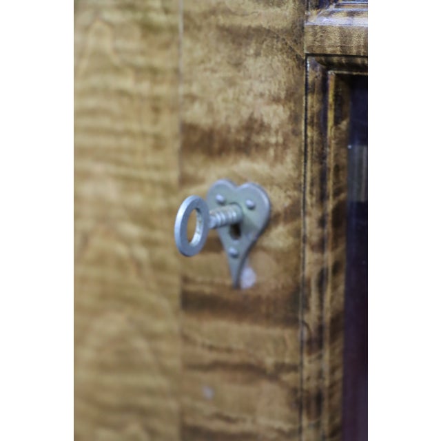 Bench-made hanging cupboard crafted in tiger maple with striking figured grain and a warm golden finish. Features a molded...