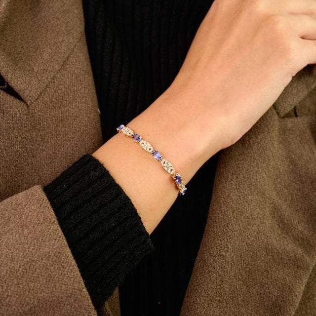 This elegant tennis bracelet 11 oval cut tanzanite totaling 5.14 carats, set in rich 14k yellow gold. Each gem measures...