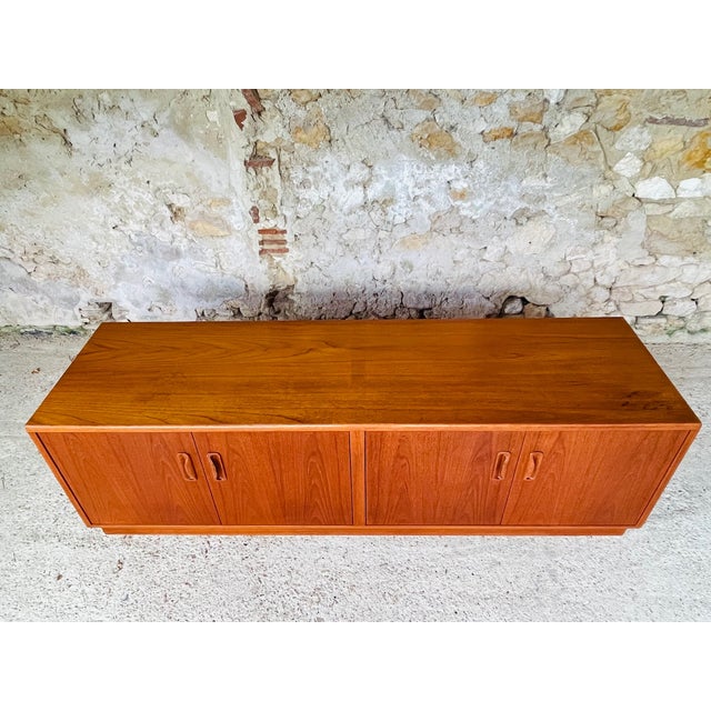 This vintage sideboard designed by victor wilkins for g-plan, is made of teak . It has two storage cabinets with center...