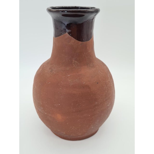An original, antique vessel made of red utilitarian pottery, likely originating from Europe and dating to the late 19th /...