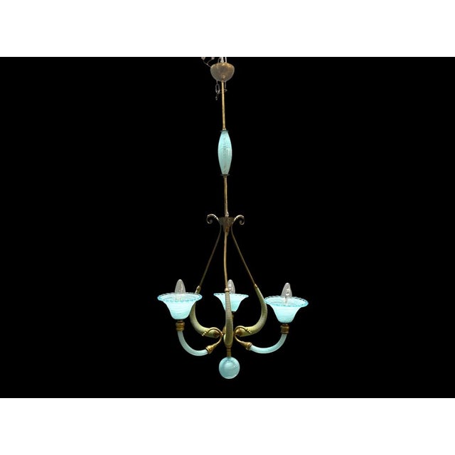 A charming italian chandelier from the 1950s, featuring elegant murano glass elements in a soft blue tone combined with...