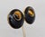 1970s goldtone round slightly domed black enamel with cabochon faux-tiger's eye at the top clip back earrings. Marked...