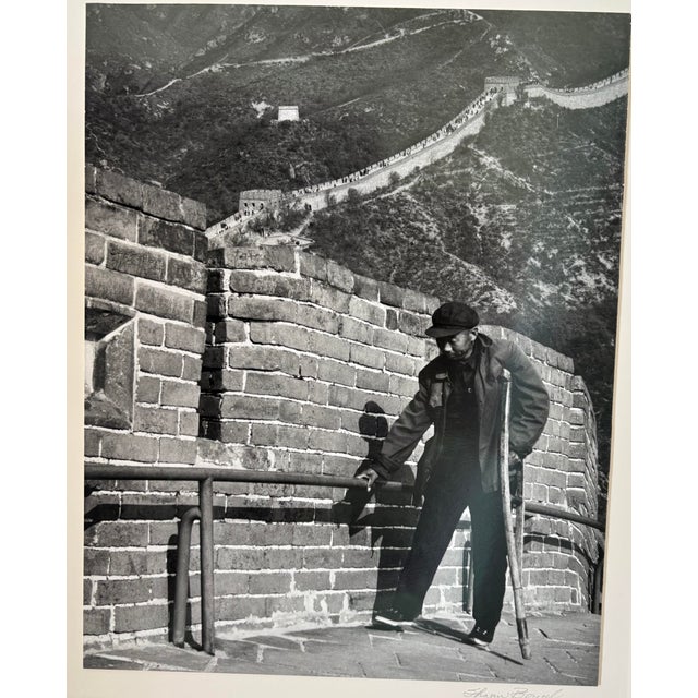 This is a framed & matted photograph of a man walking with a crutch on the Great Call of China taken by my late mother,...