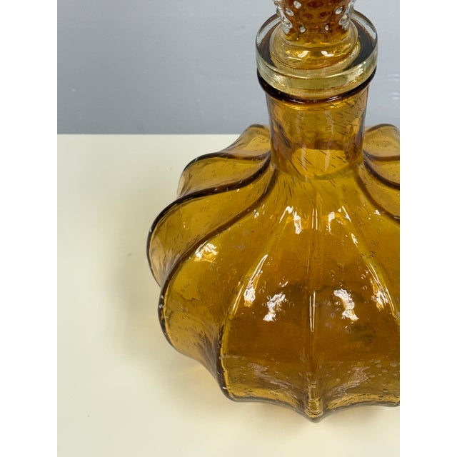 Design Plus Gallery presents the Amber Glass Decanter by Diamond Star. The molded glass body displays a sculptural, lobed...