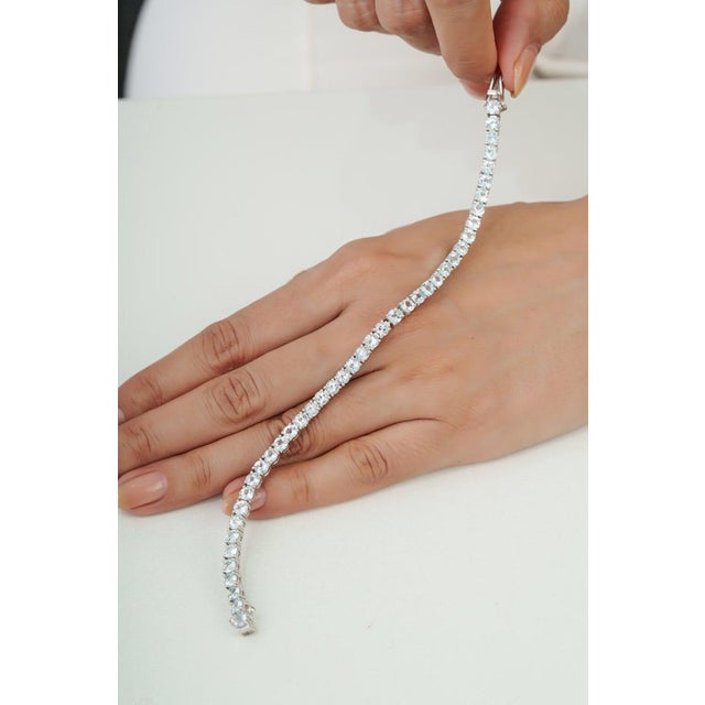 Crafted in 925 sterling silver, this 13 carat aquamarine tennis bracelet features brilliant 4.12 mm round aquamarine...