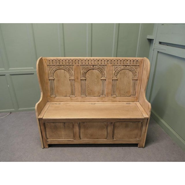 A 20th Century High Back Oak Box Settle The Settle has 3 carved back panels and the seat opens for storage The bench is a...