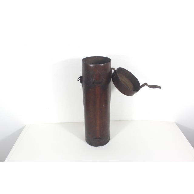 This is an old hard leather tube or canister with a lid with strap closure. This is very old, has great patina, scratches,...