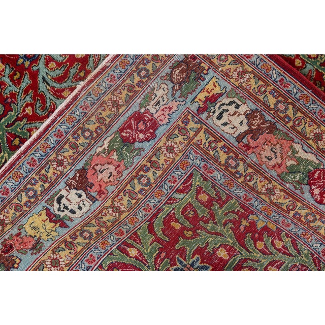 A Persian Tabriz rug, the deep red field with an allover pattern of botehs and thick green leafy vinery within a narrow...