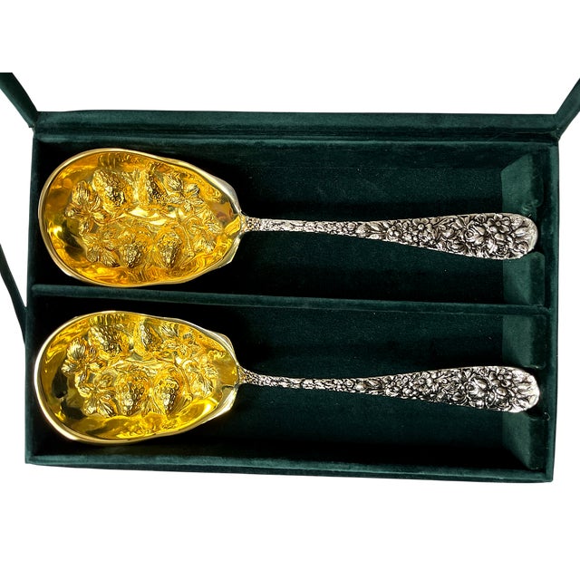 Exquisite pair of serving spoons by Godinger Silver Art Co., made exclusively for Neiman Marcus. Each spoon features a...