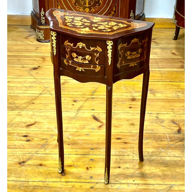 This elegant French-style side table features a beautifully shaped silhouette with a rich dark wood finish and intricate...