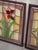 This stunning, hand-crafted stained glass panel features a vibrant red and white flower nestled among elegant green...