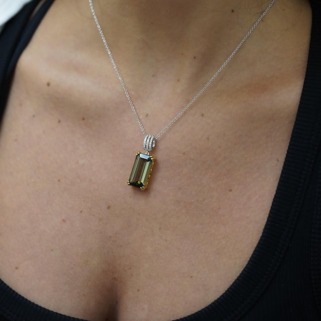 Natural 10.52 carat emerald cut forrest green tourmaline pendant in 18K white gold featuring 0.15 carat diamond accents...