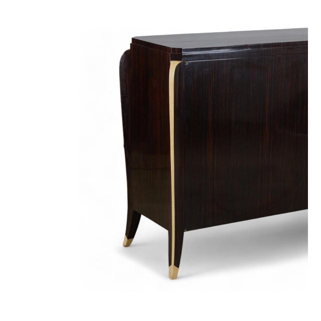 a rare Art Deco cabinet with rectangular top with notched corners above a conforming body fitted with two hinged doors...