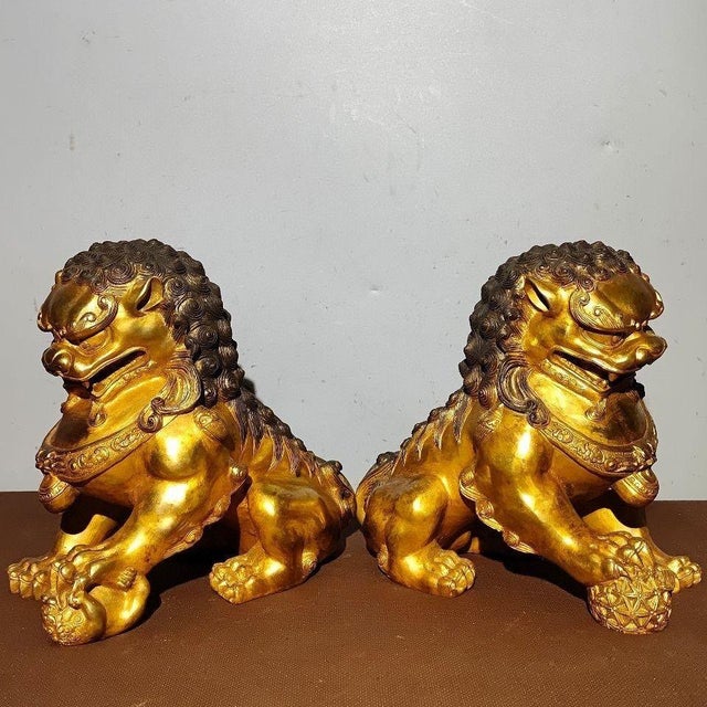 This is an impressive pair of large vintage gilt bronze guardian lions, also known as Foo Dogs or wealth lions. Each lion...