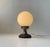 Unusual small table lamp composed of a stylized base in copper, brass and black-painted metal. Over this configuration a...