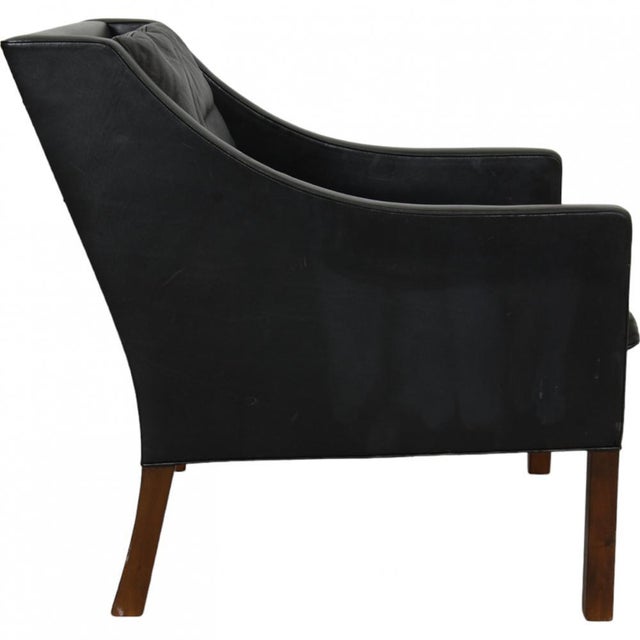 Børge Mogensen 2207 lounge chair upholstered in the original black leather and with legs of teak. The chair is from the...