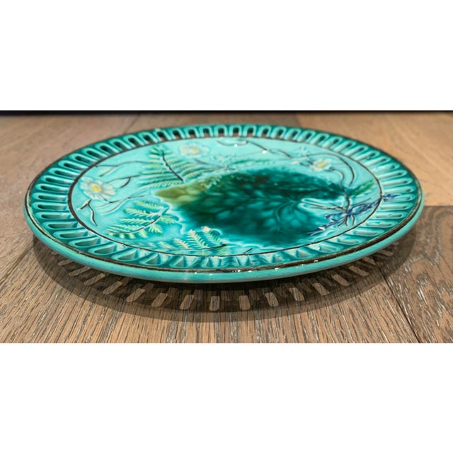 Vintage Majolica style serving dish with slotted rim. Glazed green ceramic with fern motif in different shades of green.