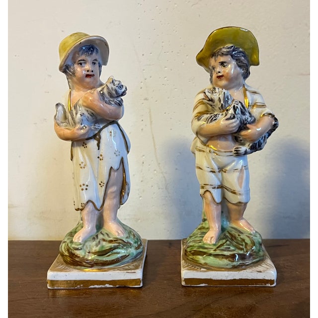 Pair antique early 19th century English figures in the Staffordshire manner, though these are porcelain. A boy and girl -...