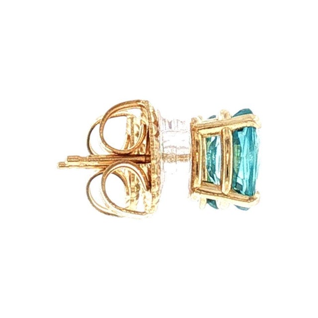 A pair of late-20th-century oval stud earrings featuring 2 natural blue zircon stones totaling approximately 2 carats. The...