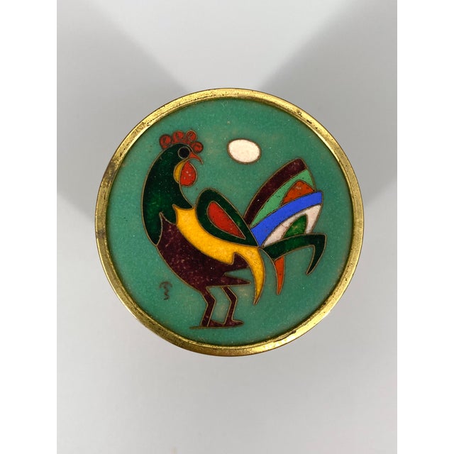 A cigarette case * Cylindrical shape * Lid with enamel inlay * Signed enamel inlay, see photos * High-quality depiction of...