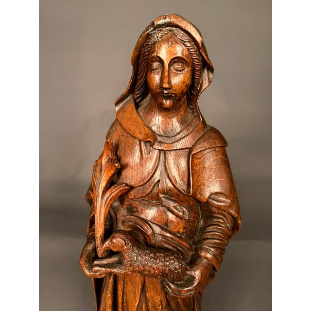 Early 19th-century Flemish hand-carved statue of Saint Agnes, dating to circa 1820 and carved from a single solid piece of...