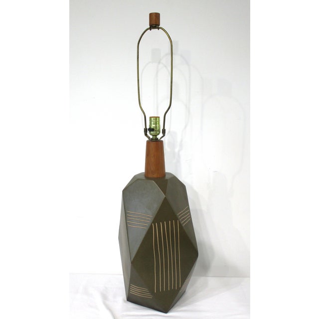 A rare geometric ceramic table lamp in a charcoal green tone with incised lighter tones to the body designed by Jane and...