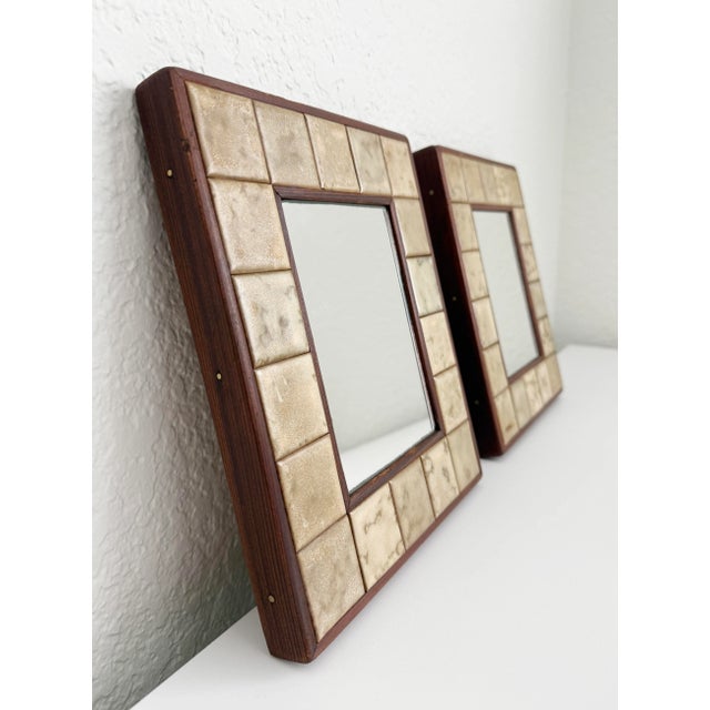 A wonderful pair of small accent wall mirrors handmade by Joel Krakauer. The mirrors are framed in rosewood and secured...