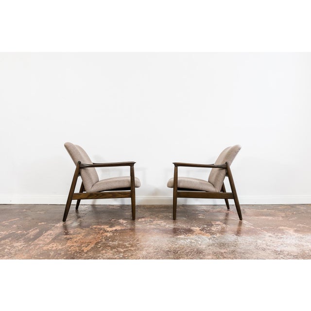 A pair of gfm-64 armchairs designed by edmund homa, produced by the gościcińska fabryka mebli (gfm) in poland during the...