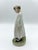 A very sweet Royal Copenhagen Porcelain Figurine Girl With Book in a white gown and cap
