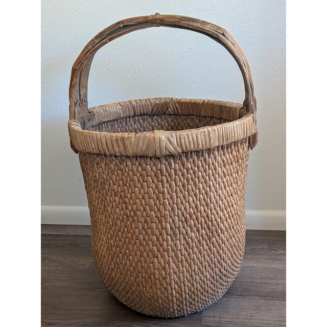 Hand woven of willow reeds with a triple hand carved bamboo handle and ring. The ring is wrapped with rattan. The handle...