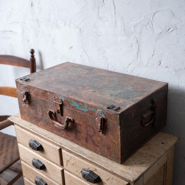 A folk art painted iron campaign trunk with hinged lid and tray, circa 1925. The body decorated with oriental man, red...