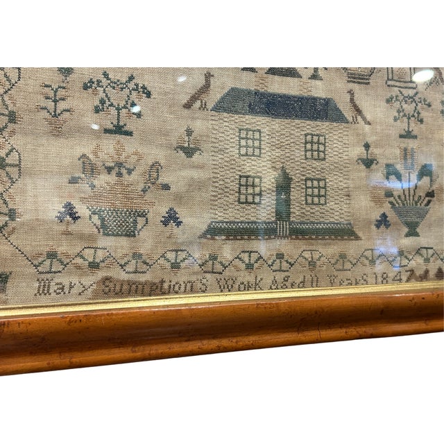 Framed Sampler dated 1842 by one Mary Sumption. House, birds, flowers: in bold birdseye maple frame. Said frame features...