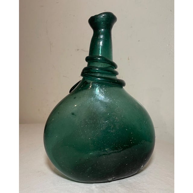 This rare antique flask is a very unique piece of Middle Eastern history. The hand blown green glass, lovely silhouette,...
