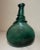This rare antique flask is a very unique piece of Middle Eastern history. The hand blown green glass, lovely silhouette,...