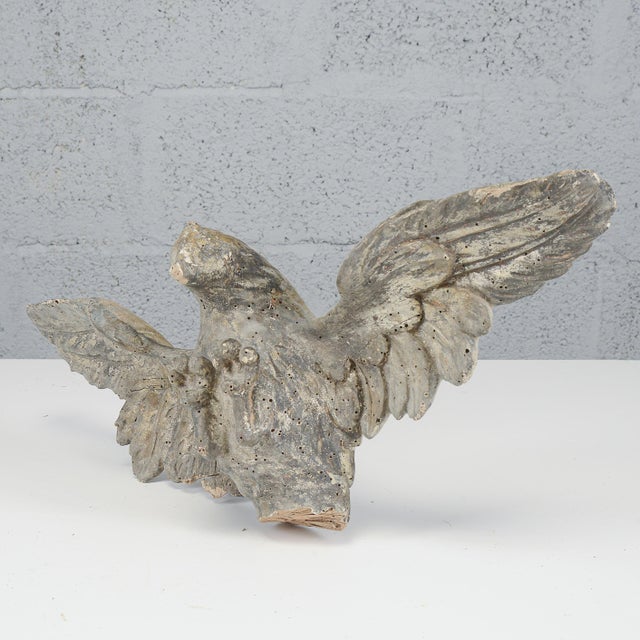 An elegant carved wooden sculpture depicting an eagle with outstretched wings, a distinctive emblem of the napoleonic era....