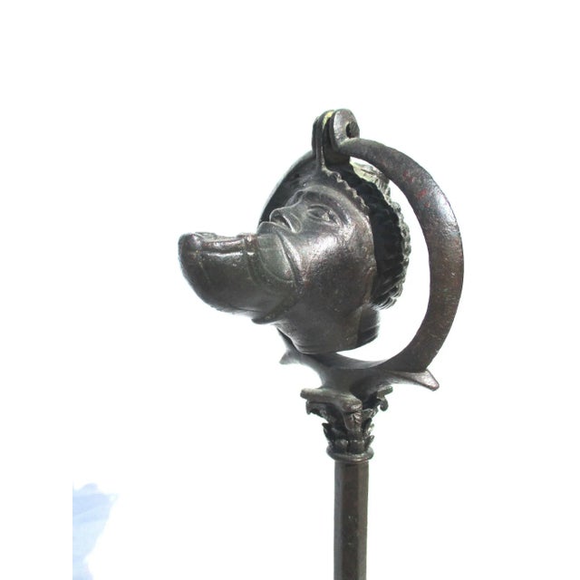 Cast bronze Roman oil lamp hung on a tall tripod stand. The lamp hangs from circular harp with a set pin driven through...