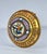 This round object is an ornate piece of Victorian-era micromosaic jewelry or decorative ware, likely Italian in origin. It...