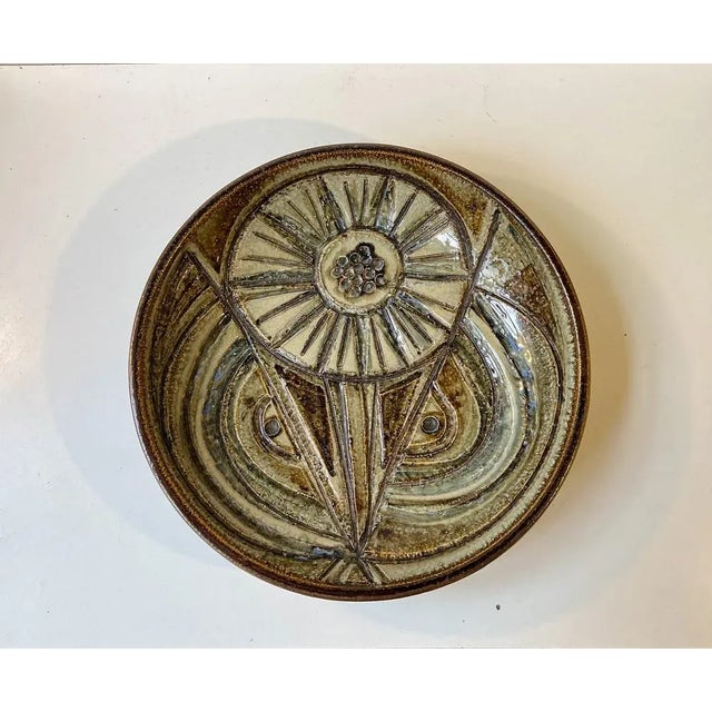 Large handmade centerpiece bowl or dish featuring a variety of earthy glazes set in an abstract sunflower looking motif....