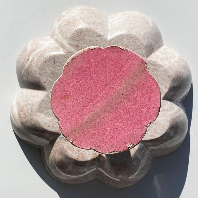 A beautiful carved circular pink stone fruit bowl sits upon a pedestal base. With gorgeous veining in pale pinks and...
