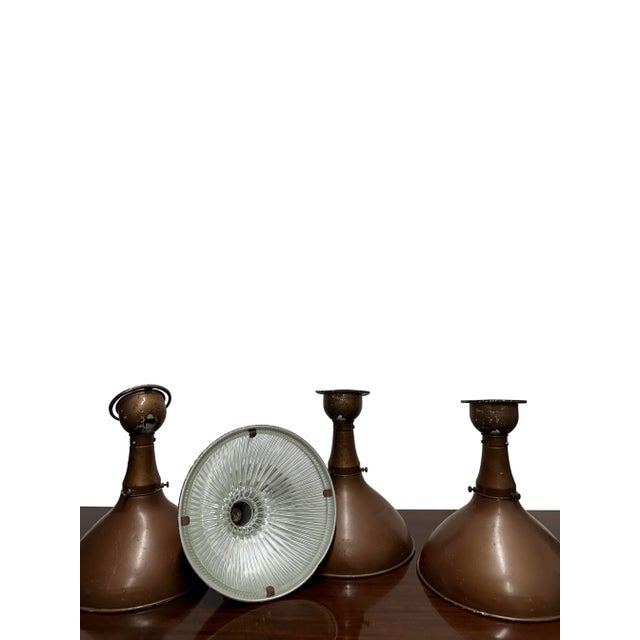 - An early set of four industrial wall lights by Holophane in their original bronze finish, England circa 1920. - The...