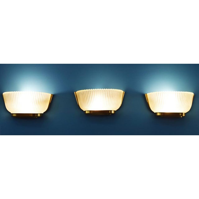 Set of 3 wall sconces in Murano glass and brass supporting structure, fully functional with original lamp holders. Made in...