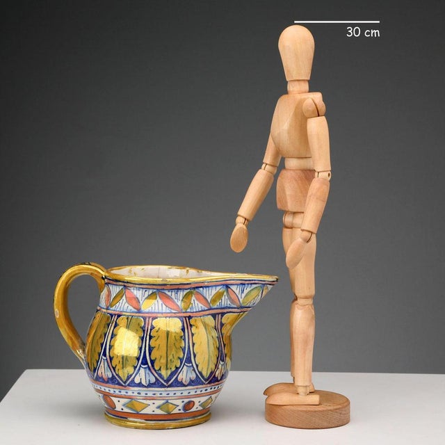 A glazed majolica jug decorated with an acanthus leaf motif. The base bears the manufacturer's trademark 'Cooperativa...