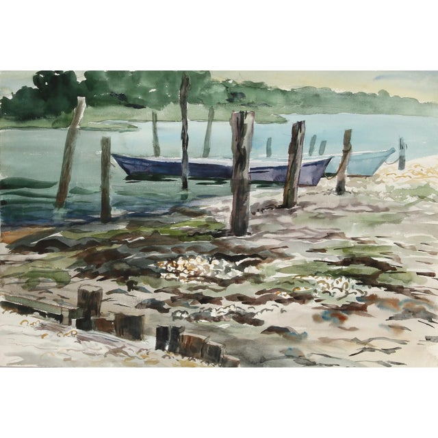 Bobbing beside the mooring amid several piers along the riverbank, Eve Nethercott's two canoes are banked along the sandy...