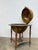 A globe bar serving table, resting on a turned wooden base with four legs joined by a stretcher and finished with brass...
