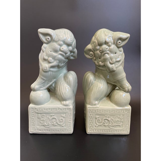 A pair of hand crafted Foo Dogs finished in a muted green glaze, offering a quiet, sculptural presence. Whether styled as...