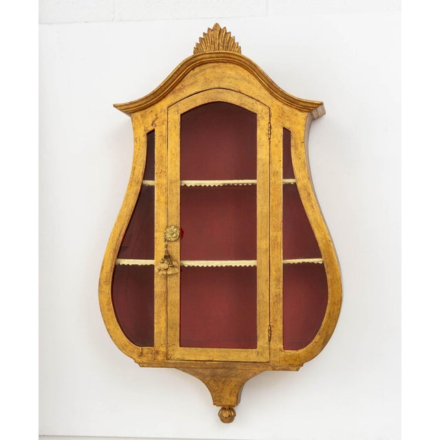 Italian Neoclassical Style Giltwood Wall-Hanging Vitrine Cabinet, lyre form with single glass-paneled door opening to...