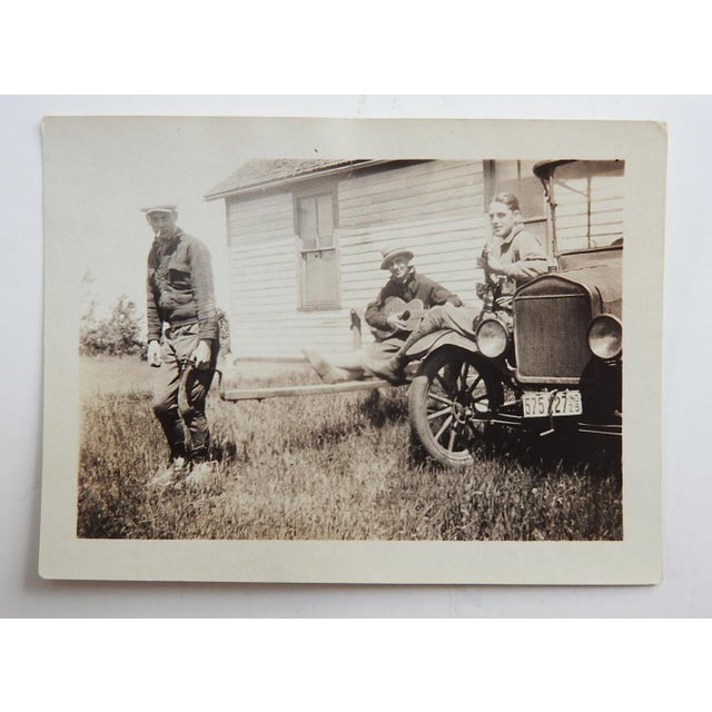 Early 20th century snapshot photograph of 3 men goofing around with guitars and a car. Unframed.