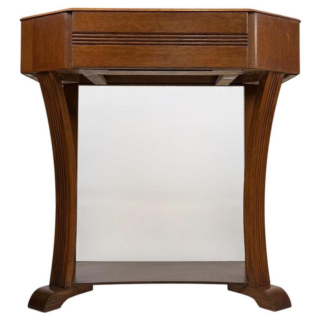 A charming vintage 20th-century English side table, finely crafted from golden oak and distinguished by its practical...