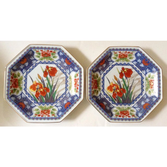 This pair of Japanese plates are beautifully decorated with central irises in bloom and a heavily decorated blue surround...